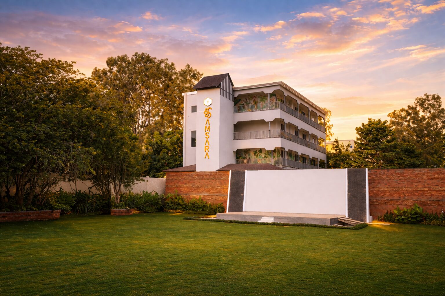 Samsara room block and lawns beneath a dramatic sky