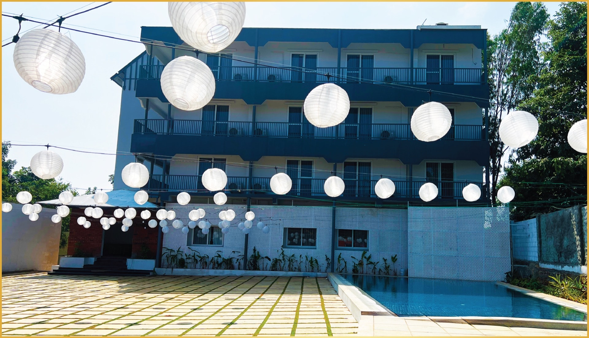 Aavya Poolside Court — white paper lanterns over swimming pool