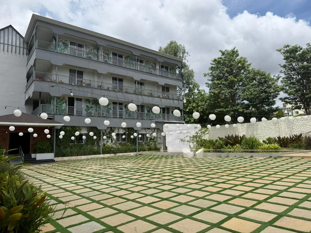 Aavya Poolside Court with paper lanterns and the adjoining Rumah room block