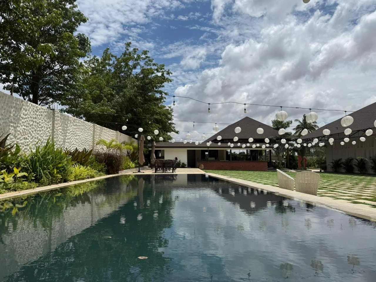 A view along the swimming pool towards the restaurant, with paper lanterns overhead