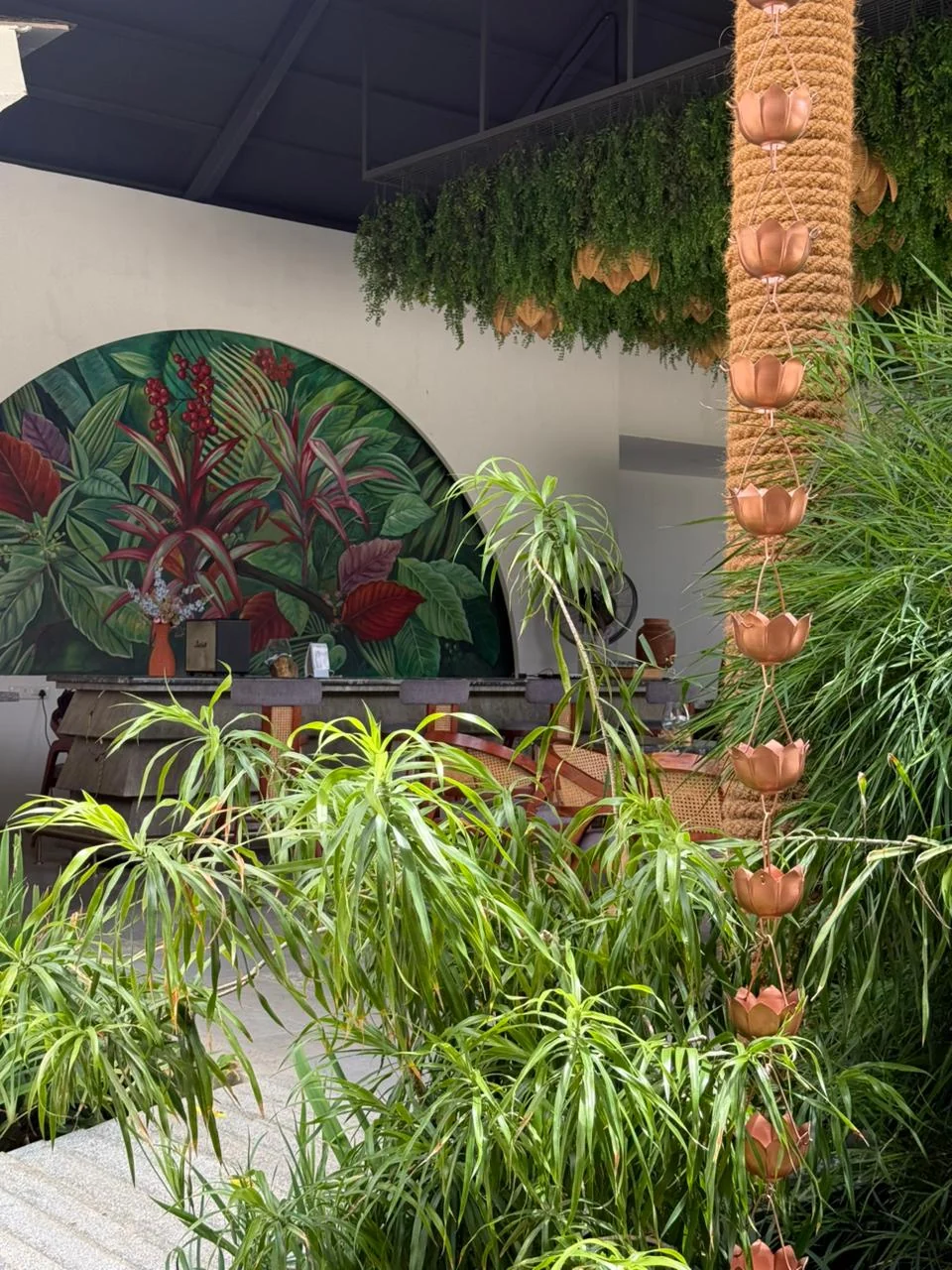 Circular botanical mural framed by planting outside the restaurant