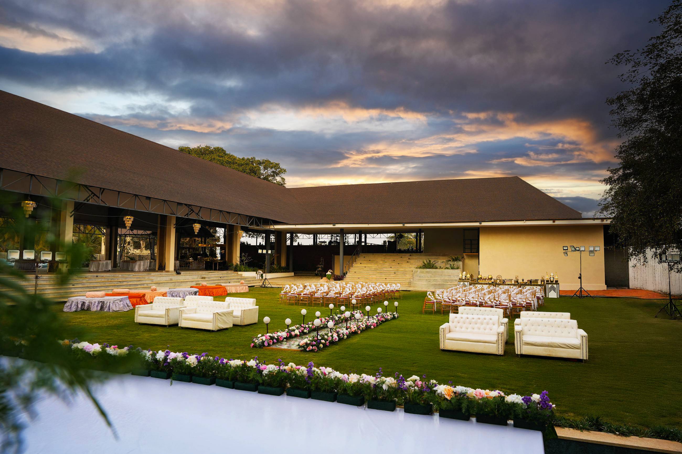 Padma Lawns with lounge seating, framed by the pavilion and Maya Dining Deck at dusk